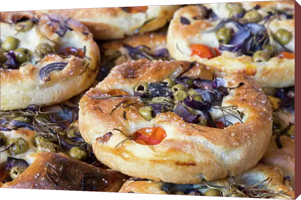 Focaccia, Italian flat bread made from yeast yeast dough with herbs, tomatoes and olives