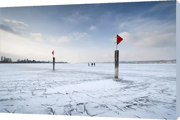 Navigation mark on a frozen Lake Constance with skaters, island auf Reichenau, Konstanz district, Baden-Wuerttemberg, Germany, Europe