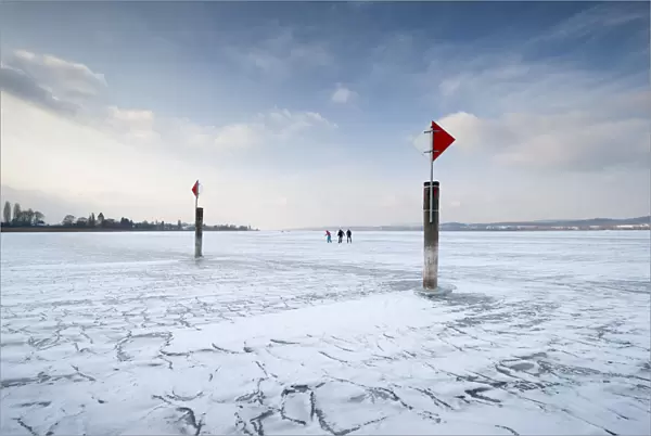 Navigation mark on a frozen Lake Constance with skaters, island auf Reichenau, Konstanz district, Baden-Wuerttemberg, Germany, Europe