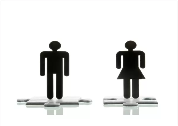 Male figure and a female figure standing on jigsaw puzzle pieces, symbolic image for looking for a partner