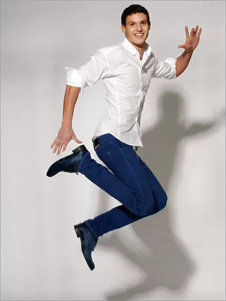 Young man in white shirt and blue jeans jumping