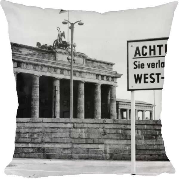 Achtung. A sign outside the Brandenburg Gate and the Berlin Wall reading Attention