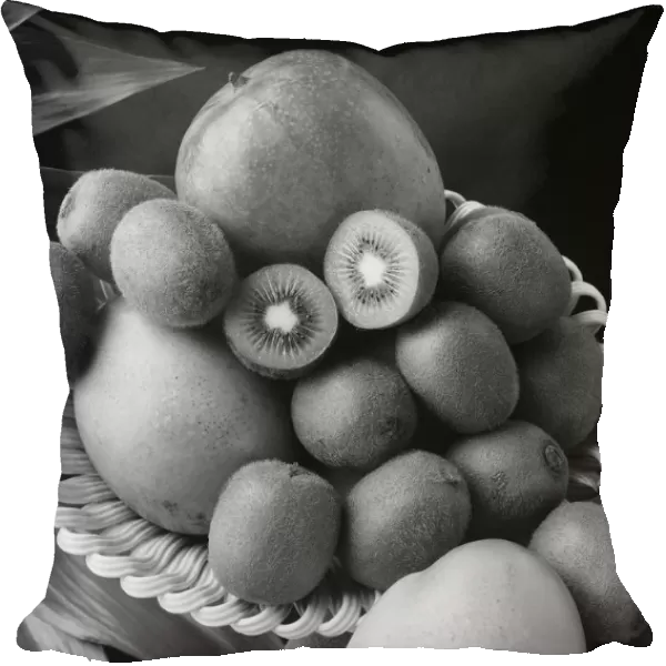 Kiwi fruits and mangos on tray against black background