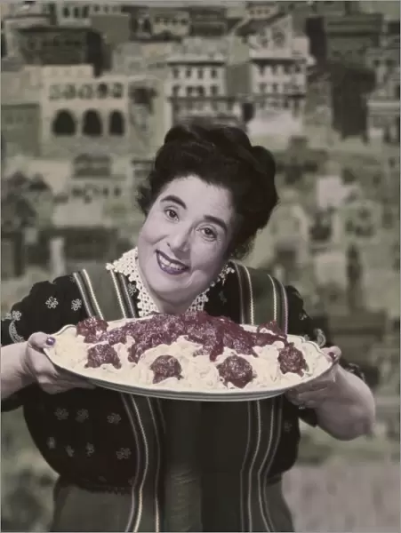 Woman holding prepared fettuccine with meatballs