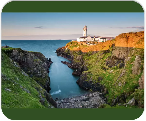Fanad Head (FAanaid) lighthouse, County Donegal, Ulster region, Ireland, Europe. Lighthouse and its cove at sunset