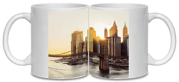 Sunset over Brooklyn Bridge and skyline of Manhattan Financial District in Downtown, New York City, NY, United States