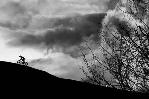 Dramatic cyclist climbing the mountain