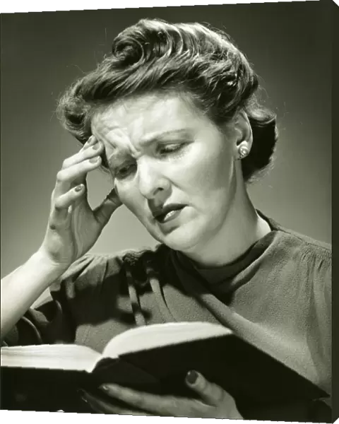 Woman with headache while reading