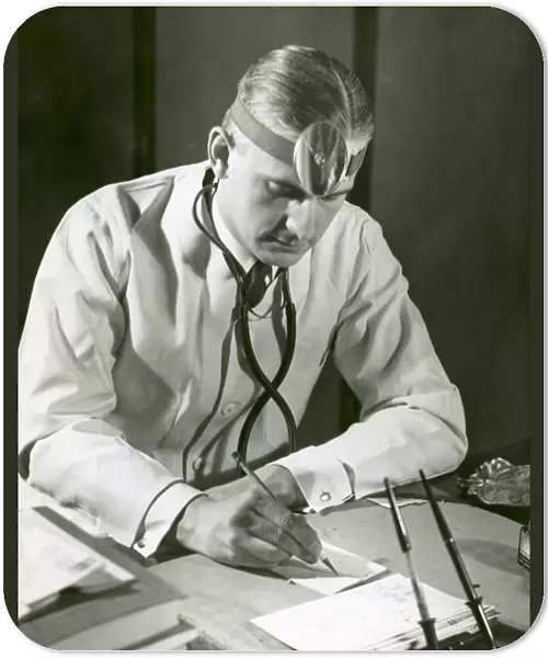 Doctor writes at his desk