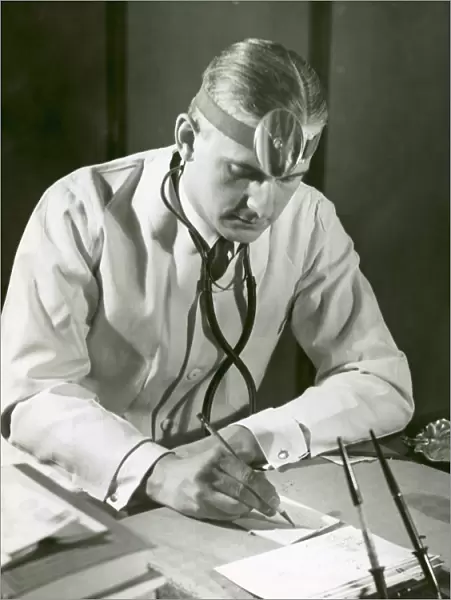 Doctor writes at his desk