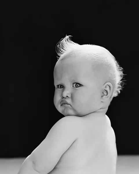 Baby looking over shoulder, with angry expression