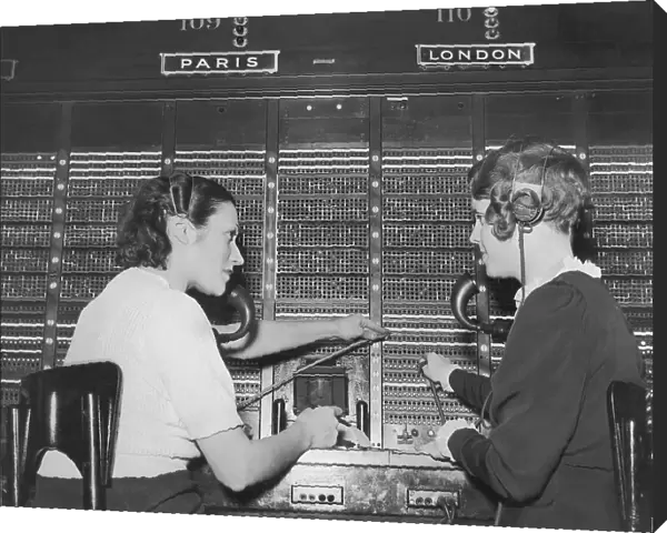Two female switchboard operators connecting international calls (B&W)