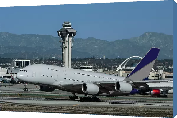 Wide body airliner taking off at Los Angeles International Airport (LAX) with control tower in background