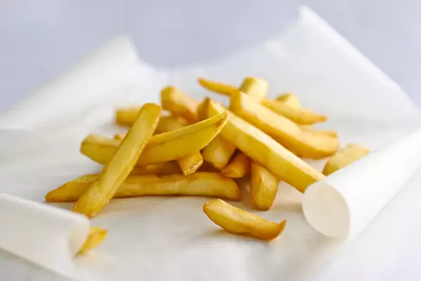 Pile of french fries on greaseproof paper credit: Marie-Louise Avery  /  thePictureKitchen
