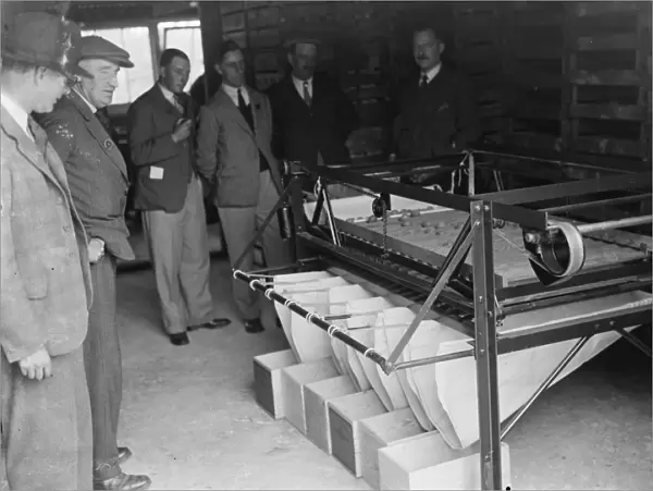 Farmers looking at machinery for fruit grading at the fruit farm. 1935