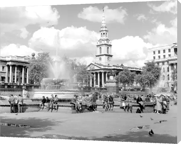 People around the fountains in Trafalgar Square with St. Magnus the Martyr in background