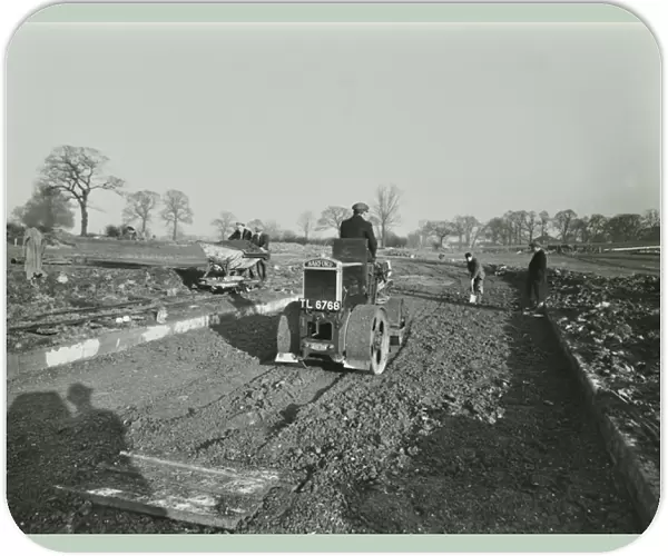 Road construction work at Chingford Estate, workers operate machinery, London