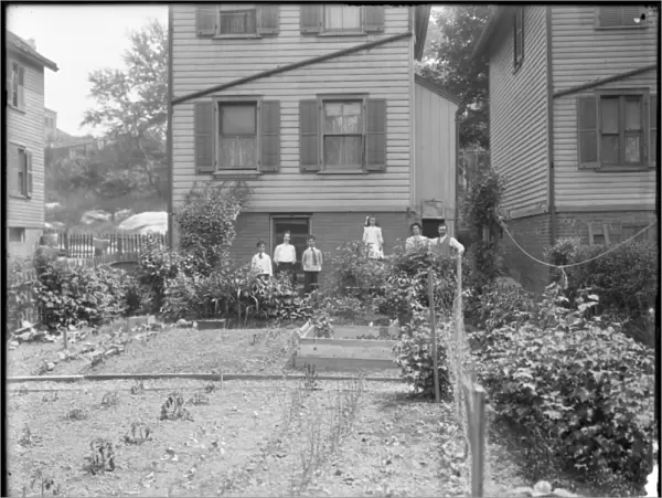 Family poses beside their backyard vegetable garden, Inwood, New York, c. 1910 (b  /  w photo)