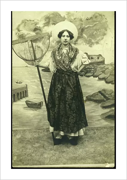 France, Nord-Pas-de-Calais, Pas-de-Calais (62), Boulogne-sur-Mer: Young woman in traditional dress from the Boulogne-sur-Mer region with a shrimp cap and net, 1905
