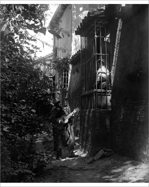 Spain: Tourists play the girl seducted by the guitarist at the feet of her balcony, 1895