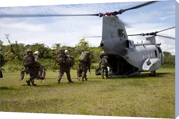 A U. S. Marine Corps CH-46E Sea Knight embarks Marines for transportation