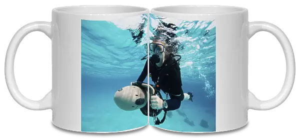 Scuba diver navigates the waters using a diver propulsion vehicle