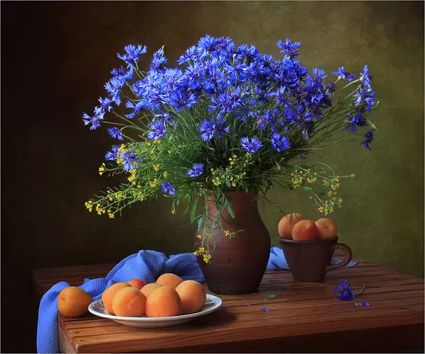 Still life with a bouquet of cornflowers and apricots