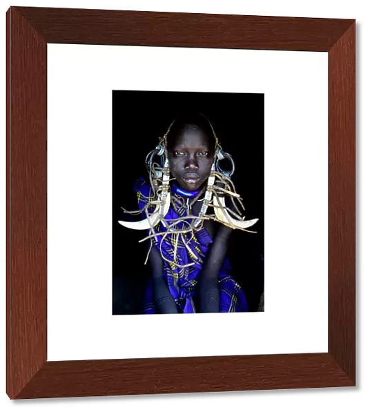 Young girl in traditional dress. Mursi tribe, Mago National Park. Omo Valley, Ethiopia