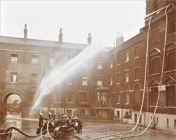 Firemen demonstrating hoses worked by a petrol motor pump, London Fire Brigade Headquarters, 1909