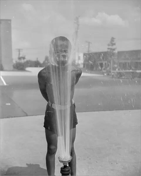 Playing in the community sprayer, Frederick Douglass housing project, Anacostia, D. C. 1942. Creator: Gordon Parks
