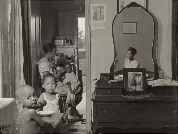 Dinner time at the home of Mrs. Ella Watson, a government charwoman, Washington, D. C. 1942. Creator: Gordon Parks