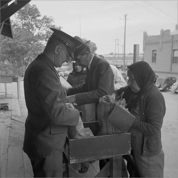 Plant quarantine inspectors examining goods bought... before entering El Paso, Texas, 1937. Creator: Dorothea Lange
