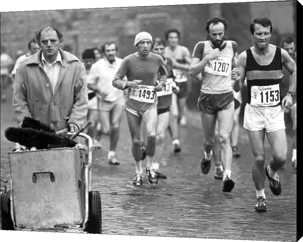 Competitors in the first London Marathon in March 1981 run past an unimpressed street cleaner