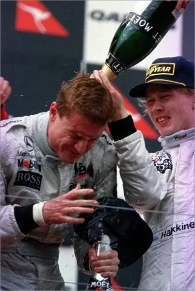 1997 AUSTRALIAN GP. David Coulthard wins the race and celebrates on the podium with team mate and 3rd placed driver, Mika Hakkinen. Photo: LAT