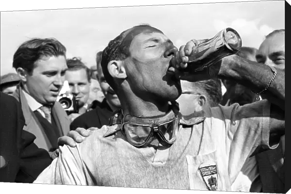 1957 British Grand Prix: Stirling Moss takes a victory drink of Coca-Cola after he and Tony Brooks won the first World Championship Grand Prix