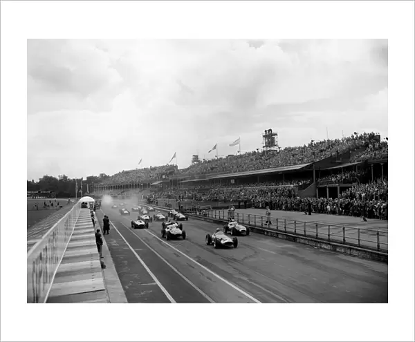 1957 British Grand Prix: Jean Behra, retired, leads at the start, with Stirling Moss, 1st position and Tony Brooks, retired, close behind, action