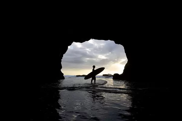Surfer Inside A Cave At Muriwai New Zealand