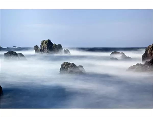 Mist Surrounding Big Rocks In The Water; Northumberland, England