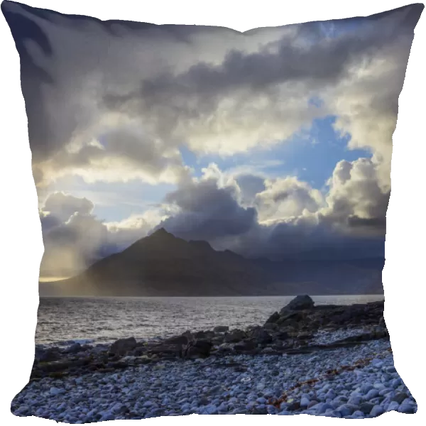 Scottish coast with sun breaking through the dramatic clouds over Loch Scavaig on the Isle of Skye in Scotland, United Kingdom