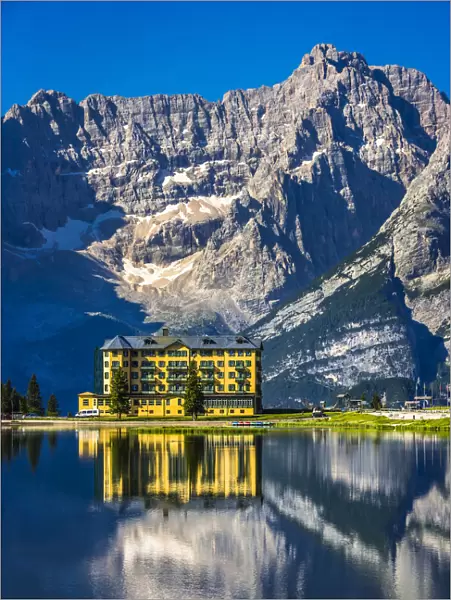 Grand Hotel Misurina reflected in Lake Misurina on a sunny day in the Dolomites in Veneto, Italy
