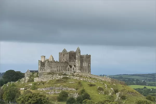 Rock of Cashel on the hilltop against a cloudy sky and Hore Abbey below, County Tipperary, Ireland