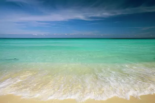 Clear blue water and wispy clouds along the beach at Cancun