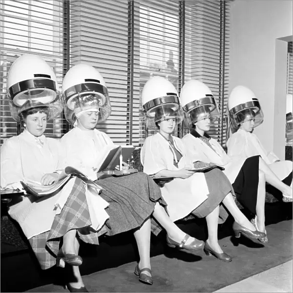Women at the hairdressers seen here under the driers, April 1956