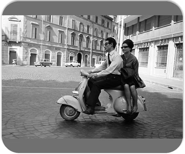 Couple driving in Milan, Italy, on a scooter