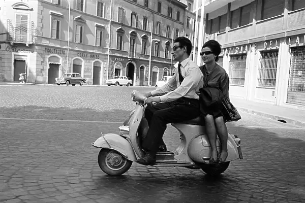 Couple driving in Milan, Italy, on a scooter