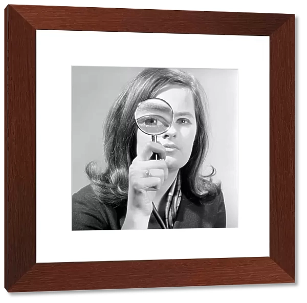 Elementary my dear Watson. Woman holding magnifying glass. Model: Jennie Cropper