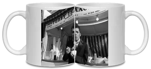 Ian Dury outside the East End stall of Tubby Isaacs eating bowl of Jellied eels