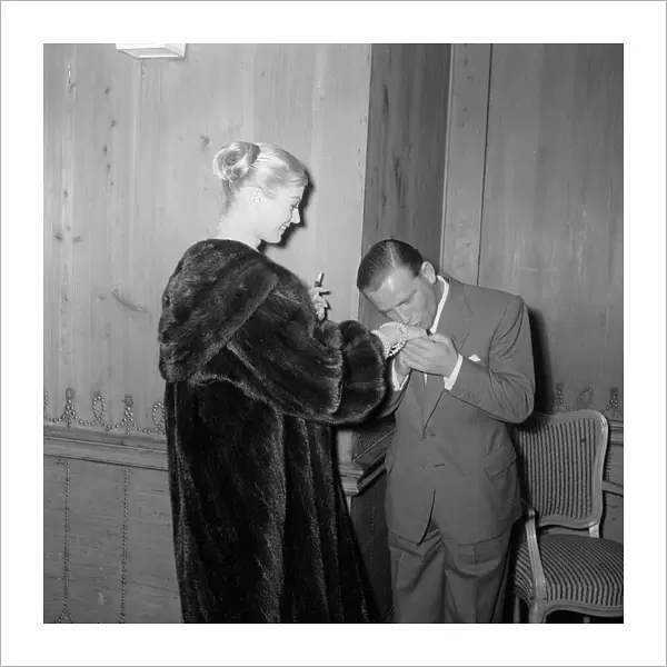 Actor and comedian Norman Wisdom kisses the hand of actress Anita Ekberg at the savoy