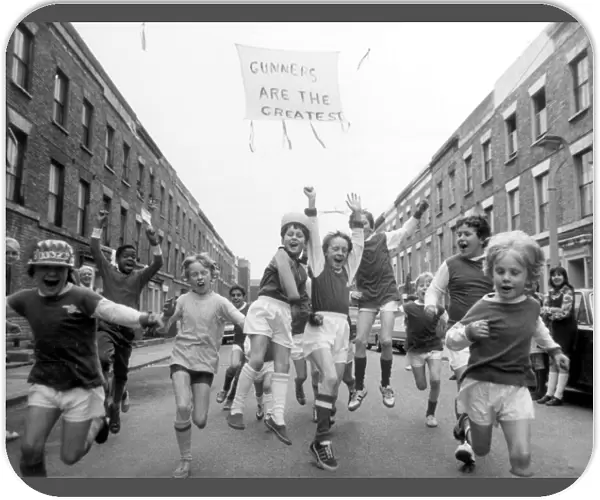 Young Arsenal fans on Blundell street, Islington, cheer for the upcoming victory against