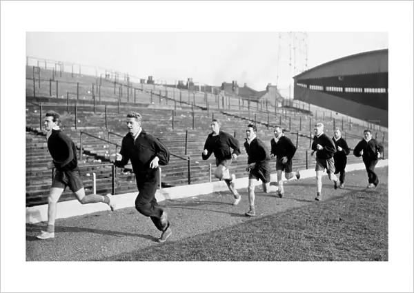 Stoke City players take part in training session, sprinting along the touch line are
